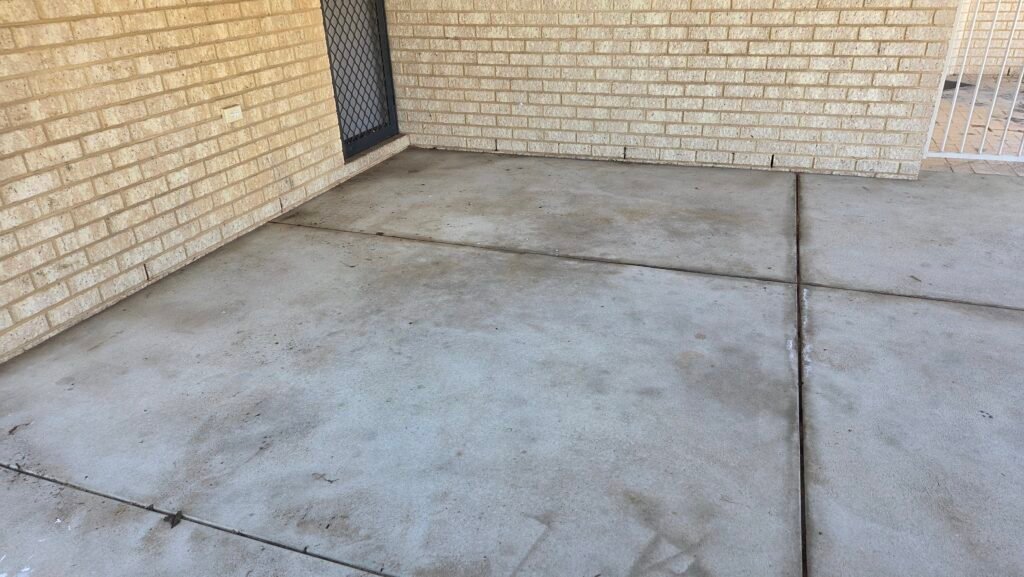 Concrete garage floor in Perth showing oil stains, dirt and discolouration before pressure cleaning